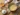 Whisking egg yolks and sugar over simmering water in a double boiler, then mixing in mascarpone until smooth and creamy.