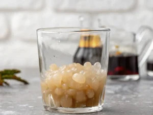 Iced Matcha Boba Tea in a clear tumbler showing chewy tapioca at the bottom
